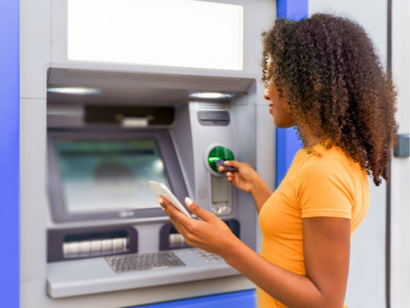 Black woman withdrawing money from an ATM
