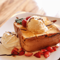 Thick slice of toast with ice cream strawberries and chocolate sauce