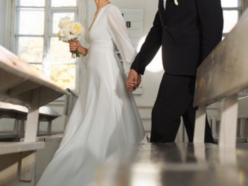 Bridal couple walking together down church aisle
