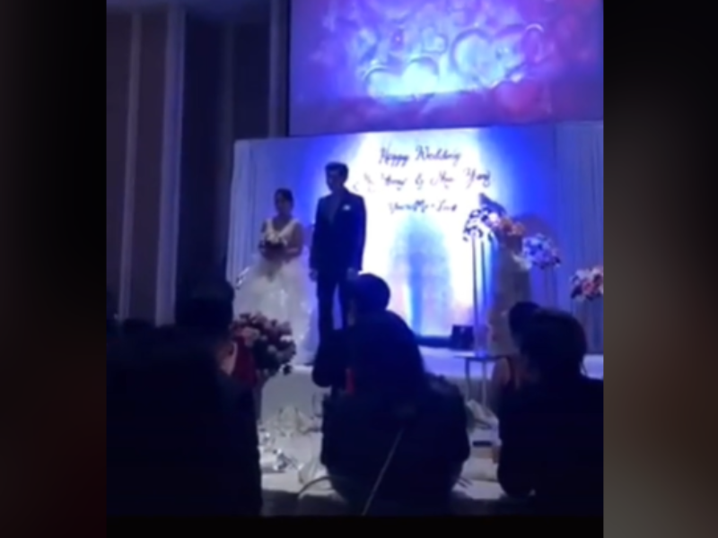 Bride and Groom standing on a stage