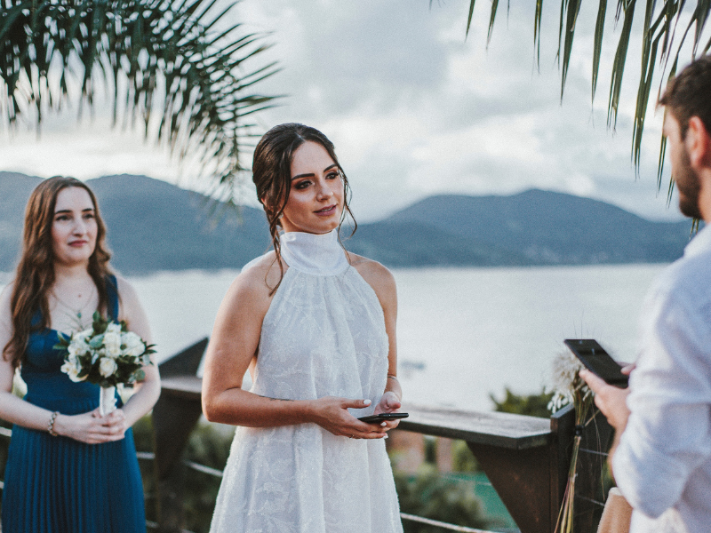 Bride and groom saying the vows with bridesmaid behind the bride
