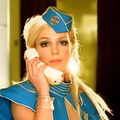 Britney Spears wearing a bright turquoise flight attendant uniform