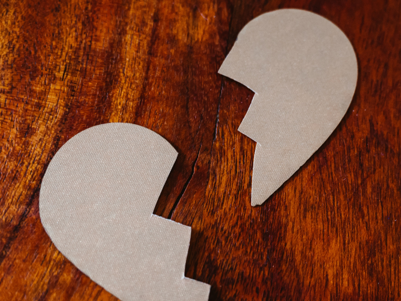 Broken heart cardboard on brown wooden table top