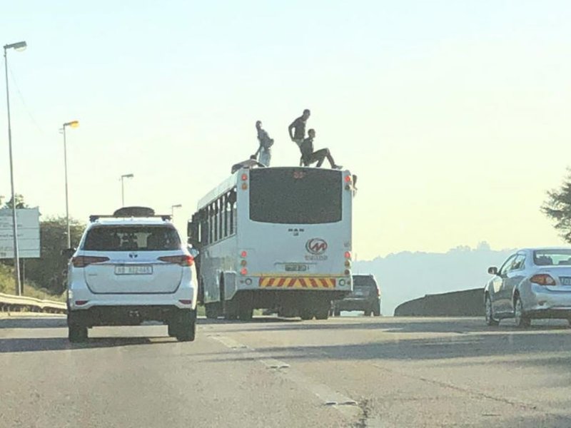 A couple of guys stand on a bus wanting to surf like they would see at the beach