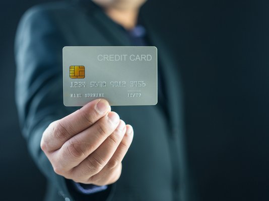 Business man holding up credit card