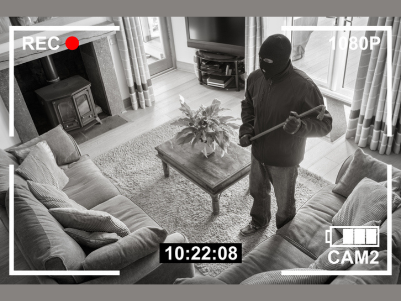 CCTV Surveillance security camera of a burglar breaking into a home