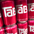Cans of Tab soda lined up on a shelf