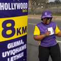 Carol Ofori dances next to the 8km mark at Hollywoodbets run