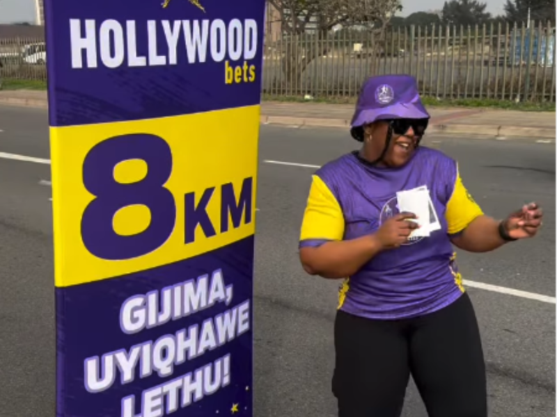 Carol Ofori dances next to the 8km mark at Hollywoodbets run