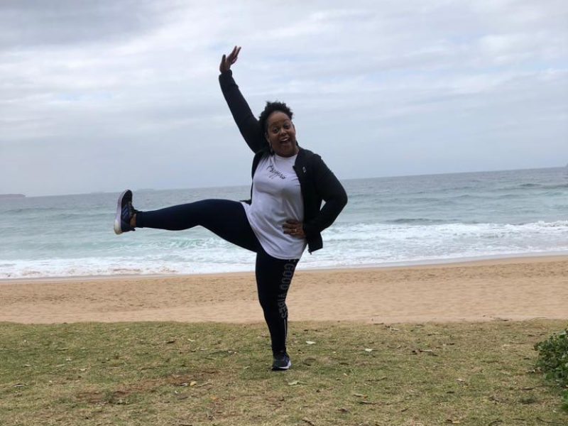 Carol Ofori dancing in front of the beach