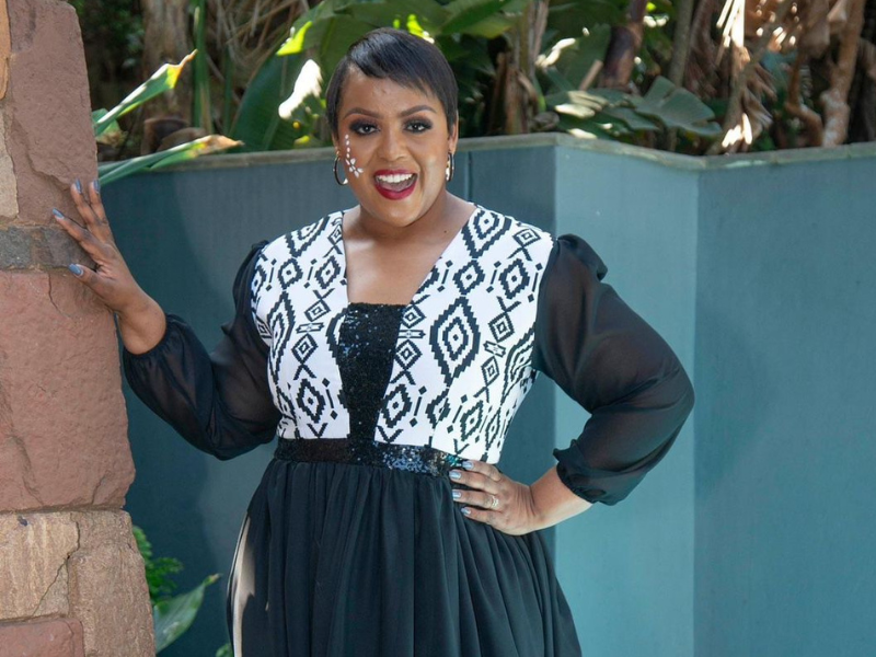 Carol Ofori dressed in Silomo dress posing by a tree