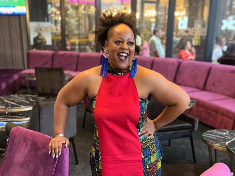 Carol Ofori leaning on a chair smiling