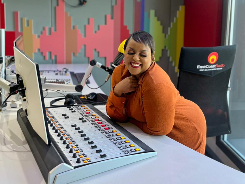 Carol Ofori leaning on desk inside East Coast Radio studios