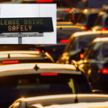 Cars in a traffic jam and a digital safety sign