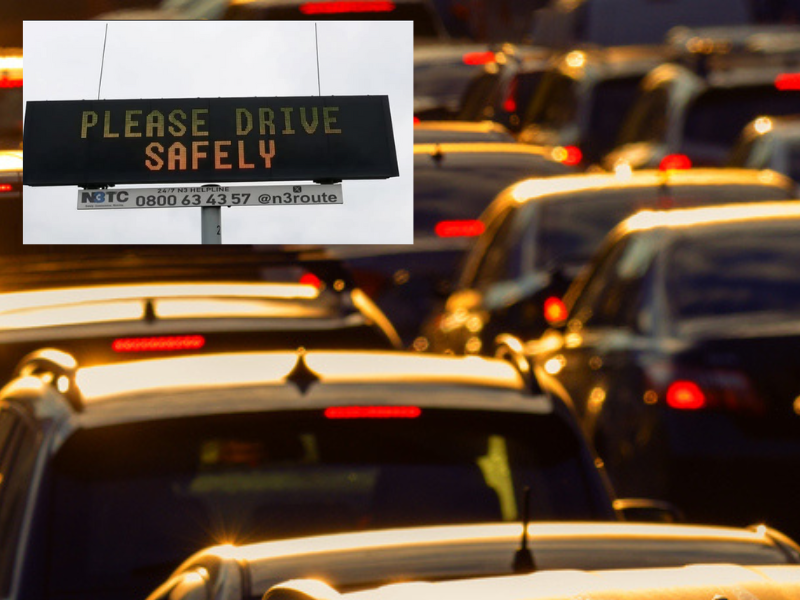 Cars in a traffic jam and a digital safety sign