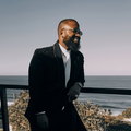 Cassper Nyovest poses on a balcony with a seaview
