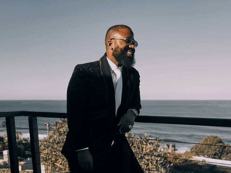 Cassper Nyovest poses on a balcony with a seaview
