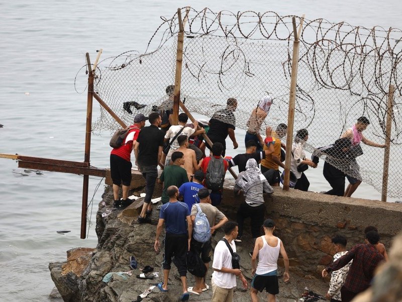 Migrants crossing from Morocco into Spain's north Africa's Ceuta enclave in July 2026