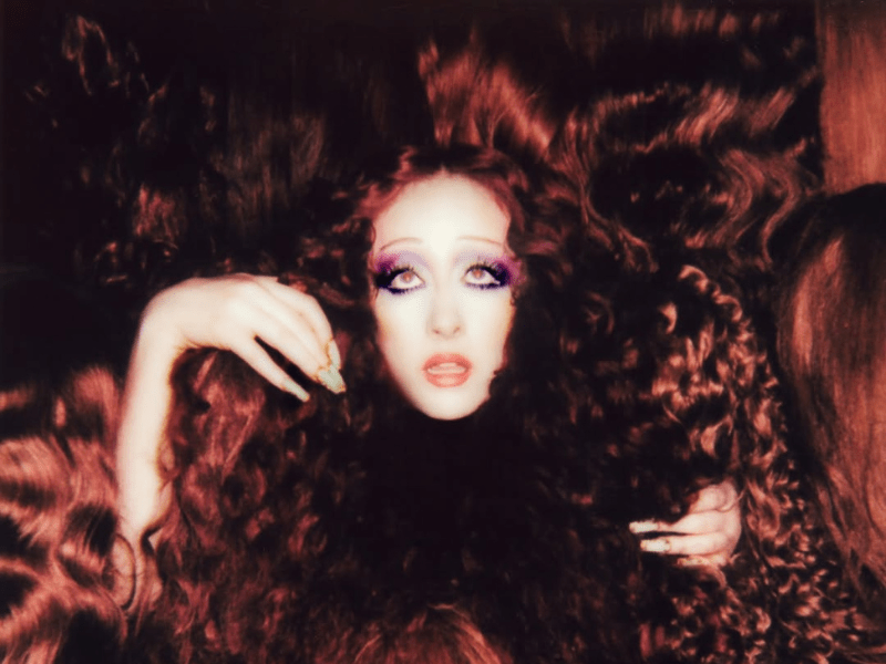 Chappell Roan with voluminous, curly auburn hair