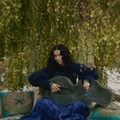 Charli XCX plays a large string instrument