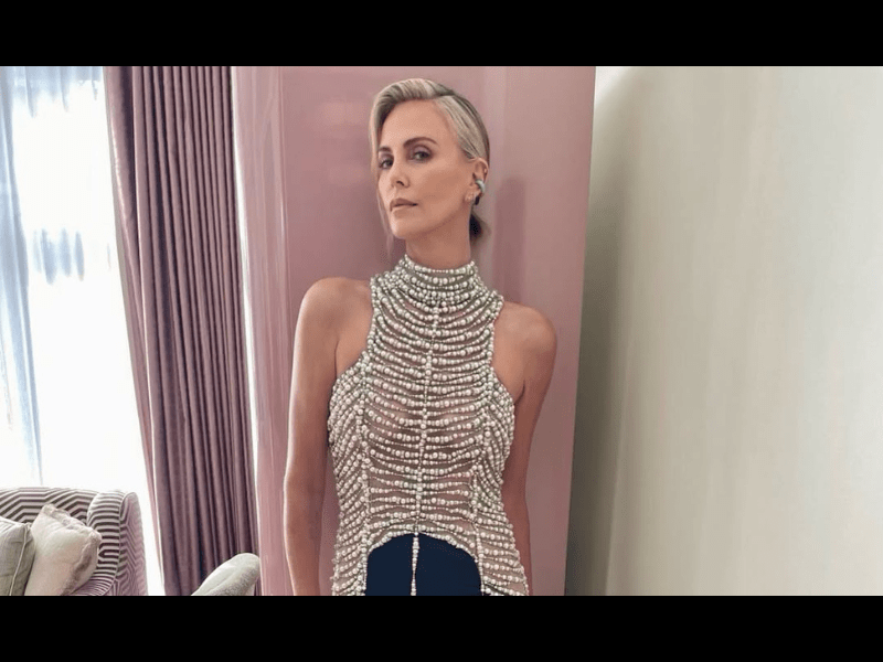 Charlize Theron wears a high neck dress embellished with pearls