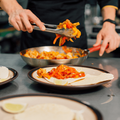 Chef preparing tacos on a steel table