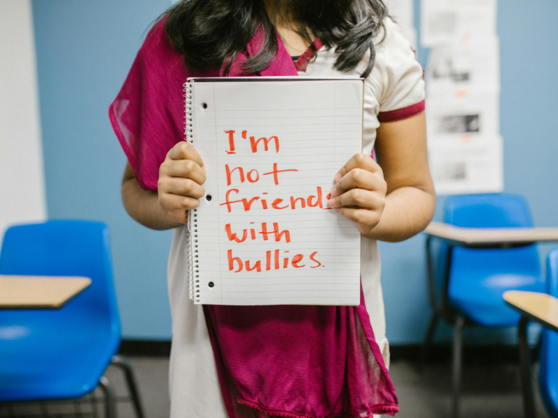 Child showing a message about bullying in her notebook