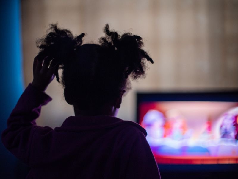 Child watching tv and holding hair