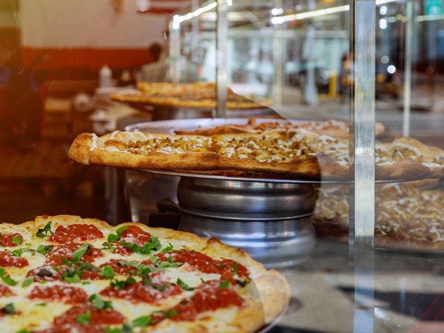 Close-Up Of Pizza In Kitchen At Restaurant