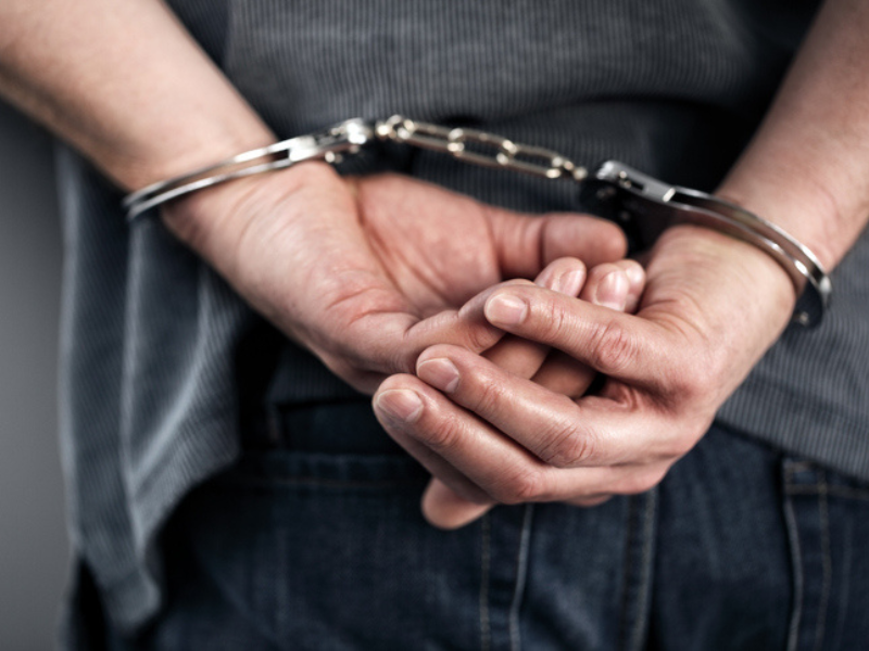 Close up of cuffed criminal hands