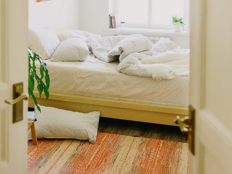Comfy bed in stylish room with messy sheets