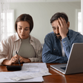 Stressed couple calculating expenses