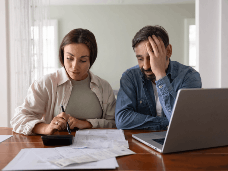 Stressed couple calculating expenses