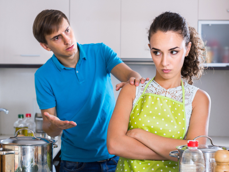 Couple with serious faces argue in a kitchen