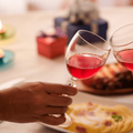 Couples celebrate by drinking red wine over a meal