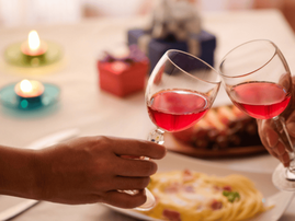 Couples celebrate by drinking red wine over a meal