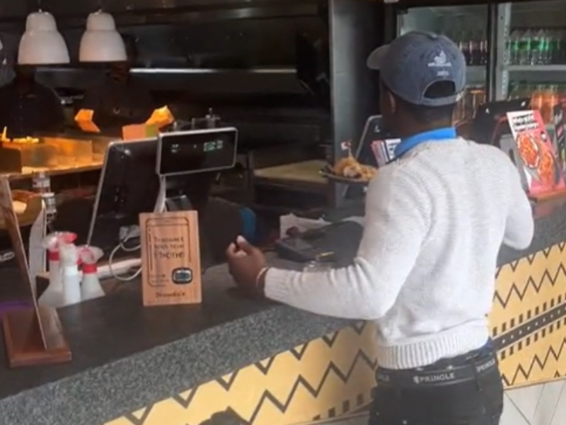 Customer standing at the cash register of a fast food restaurant