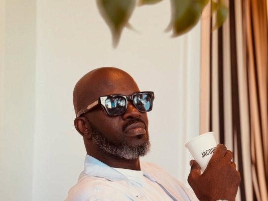 DJ Black Coffee with a drink in his hand