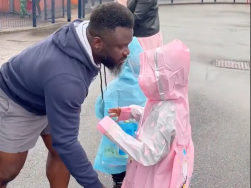Dad fixing his daughter's raincoat
