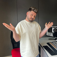 Danny Guselli holding his arms up at the East Coast Radio studios