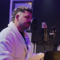 Danny Guselli sitting in his robe at his home studio
