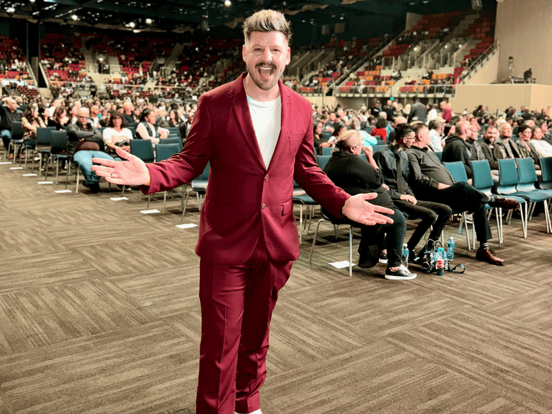 Danny Guselli standing amidst fans seated at the Durban ICC