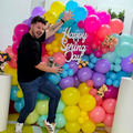 Danny Guselli standing in front of a Spring balloon display