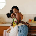 Mother and daughter embrace in a kitchen