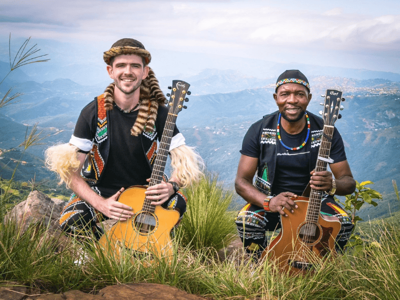 David Qadasi Jenkins and Maqhinga Radebe pose with their musical instruments in the countryside