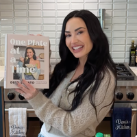 Demi Lovato holding up her new cookbook