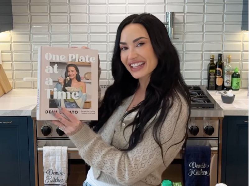 Demi Lovato holding up her new cookbook