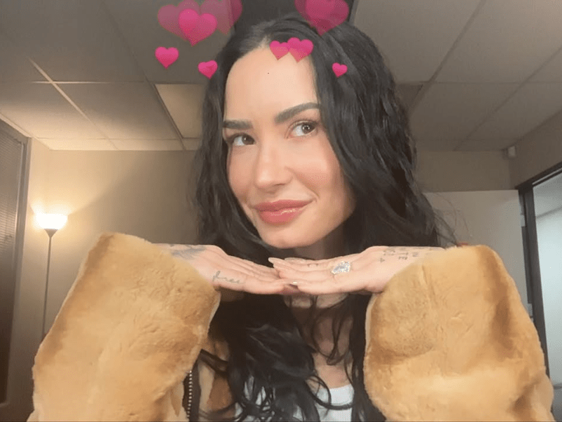 Demi Lovato poses with her chin resting on her hands