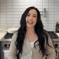 Demi Lovato poses in a modern kitchen with a sleek stovetop