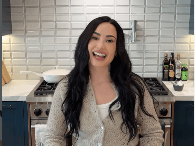 Demi Lovato poses in a modern kitchen with a sleek stovetop